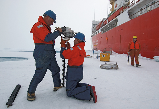 John Kemp (standing) with Kris Newhall prepare to drill a hole in the ice in the Beaufort Sea